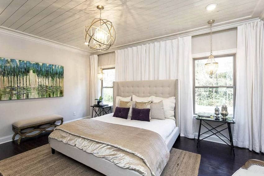 Bedroom with wall art, dark wood floors and globe chandelier