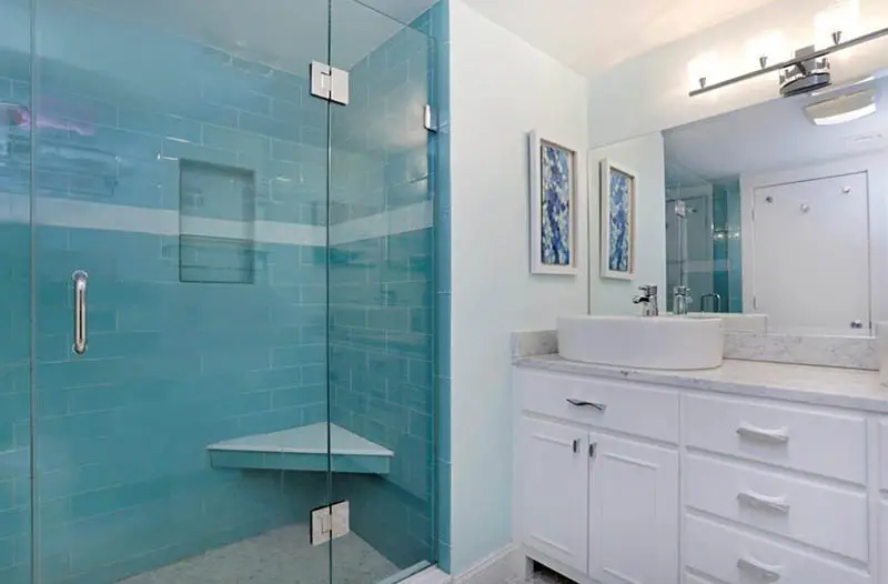 Blue tile bathroom shower with corner bench
