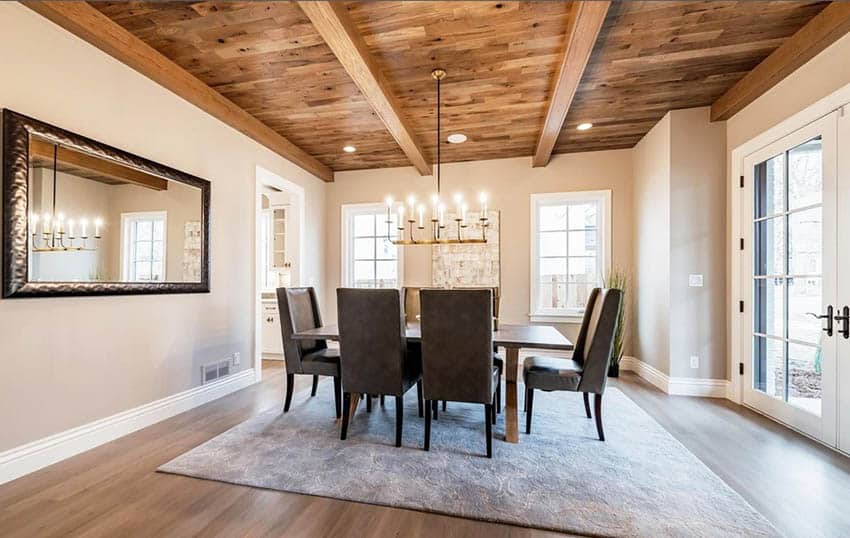 Dining room with faux wood beams wood flooring
