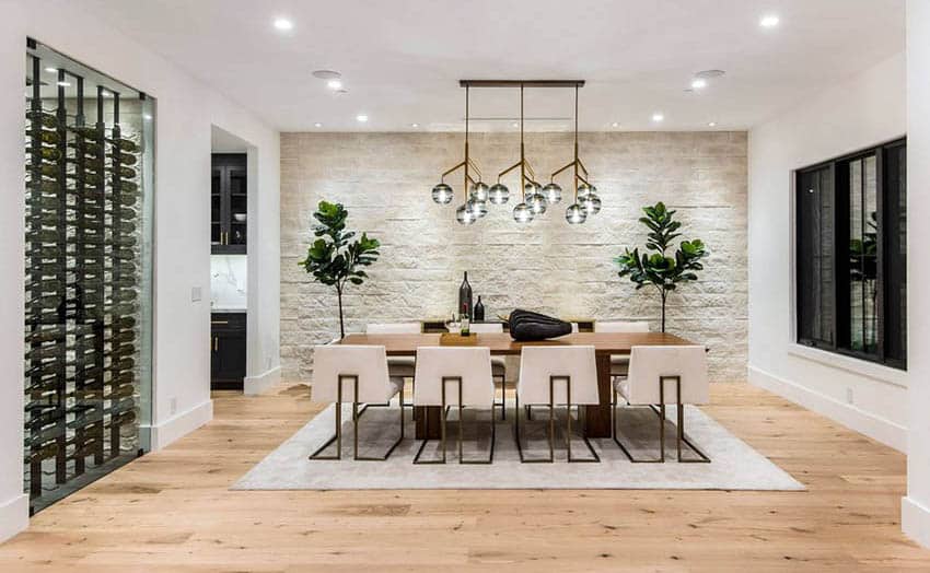 Dining room with hardwood flooring, stone accent wall and glass wine cellar