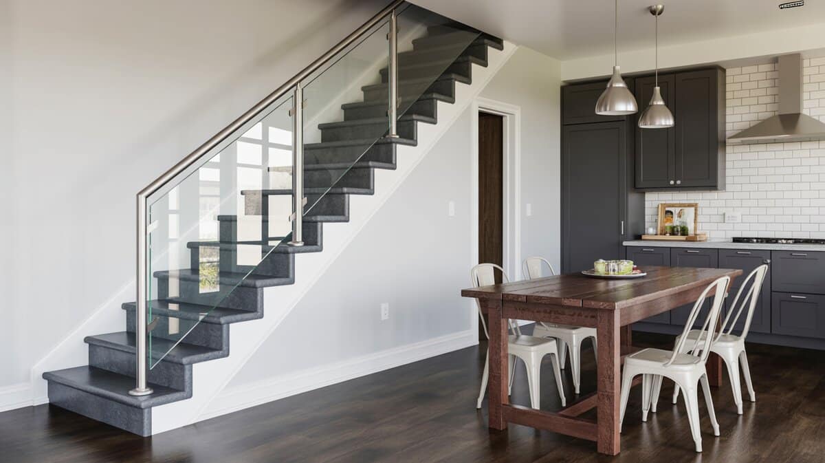 Frameless glass panel stair railing with brushed stainless steel handrail adjacent to dining area and dark kitchen cabinets