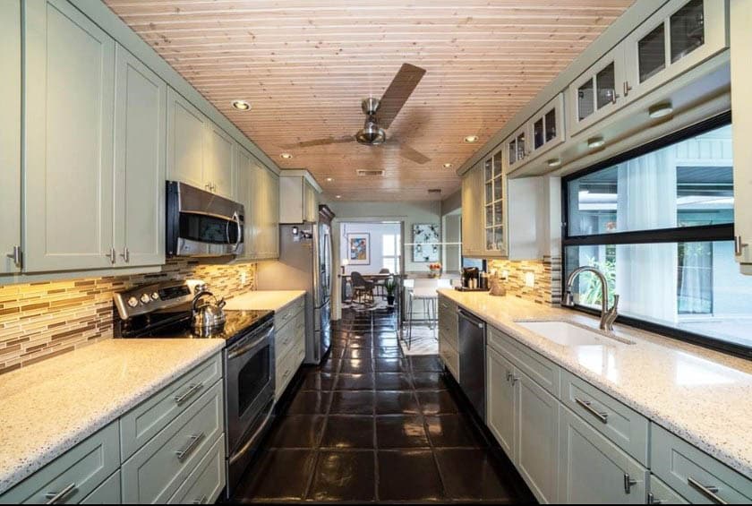 Galley kitchen with beadboard ceiling with slide up window