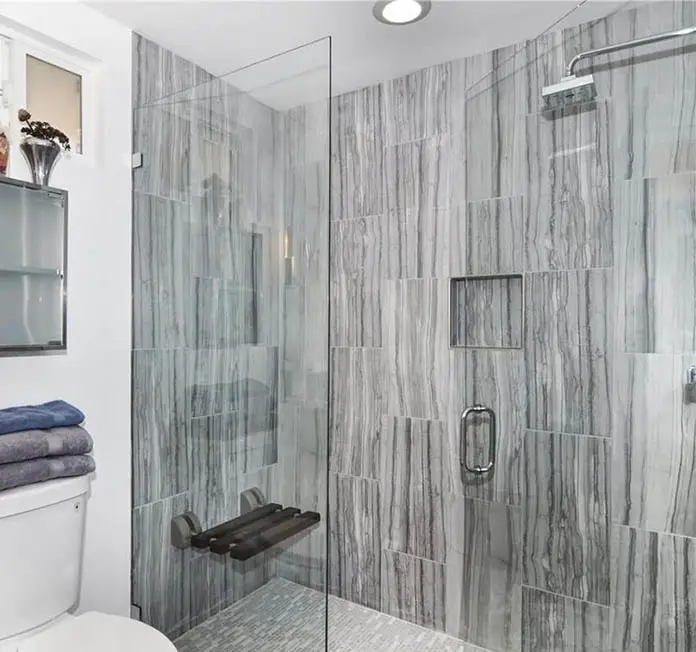 Guest bathroom with glass door shower and folding bench