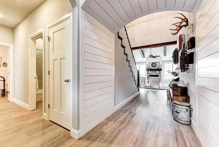 Hallway with white shiplap board walls and ceiling
