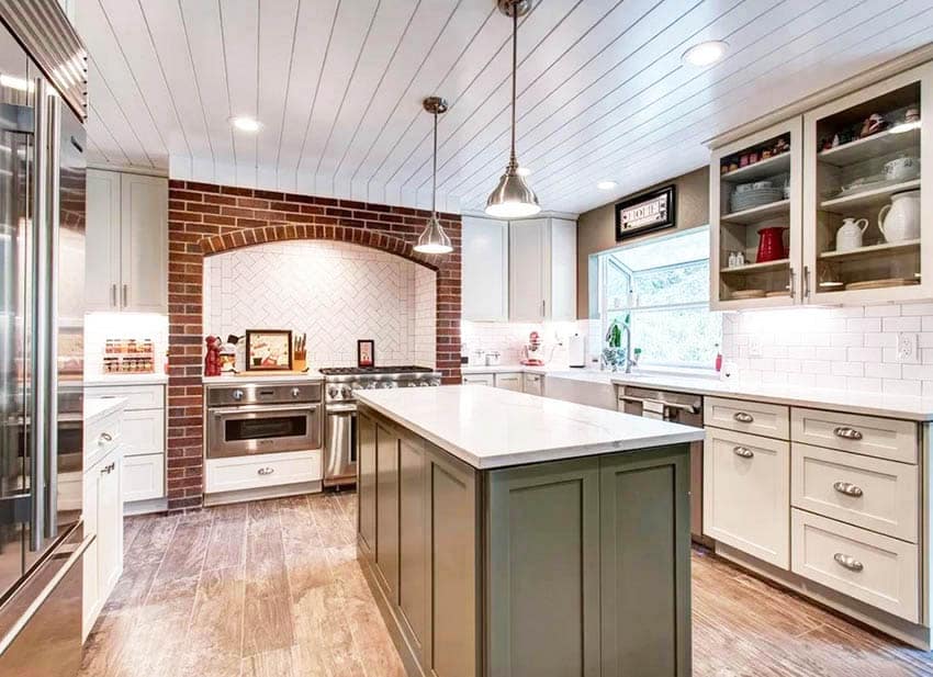 Kitchen with brick oven surround subway tile backsplash green island white cabinets