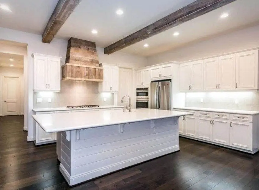 Kitchen with faux wood ceiling white cabinets shiplap island and wood flooring