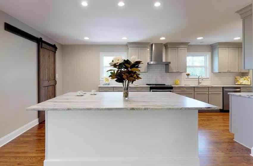 Kitchen with gray cupboards and white subway tile