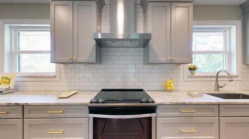 Kitchen with gray cabinets white subway tile marble countertops