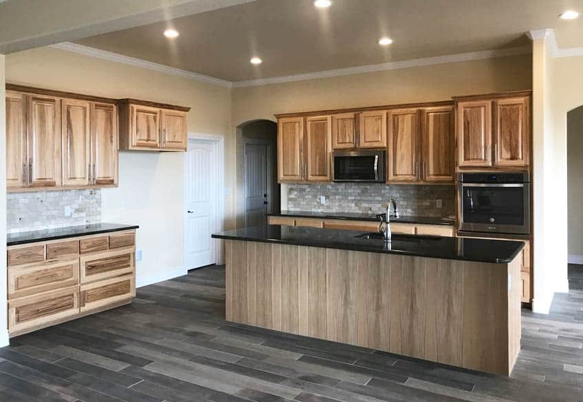 Kitchen with hickory cabinets dark vinyl floors and black granite counters