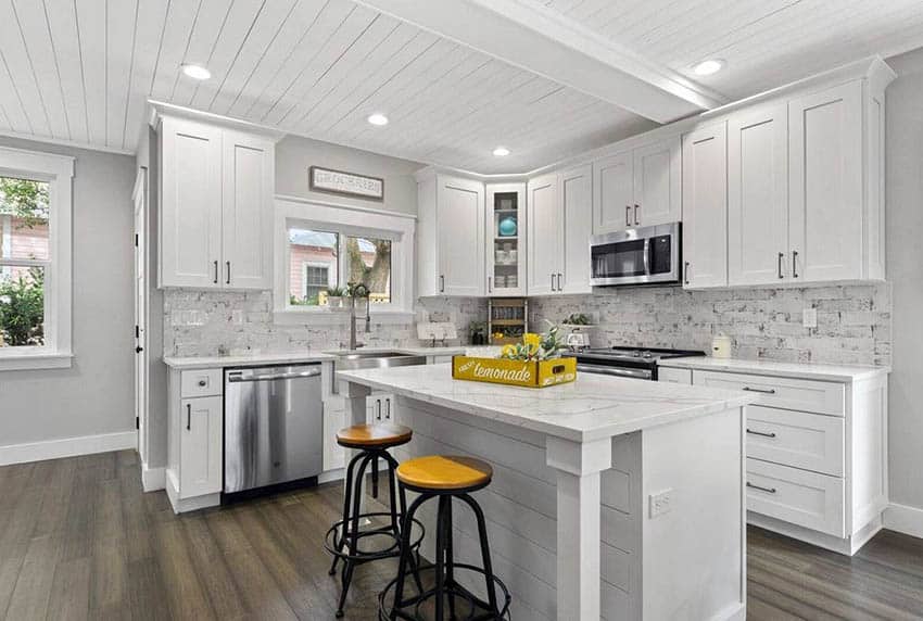 Kitchen with shiplap ceiling, white cabinets, marble countertops and wood flooring