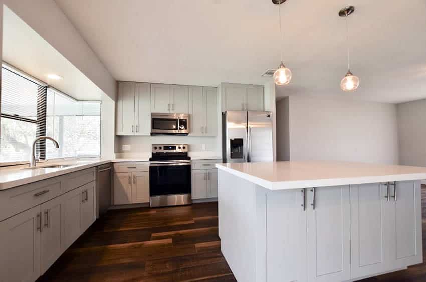 Kitchen with small island with white counters, white ceilien