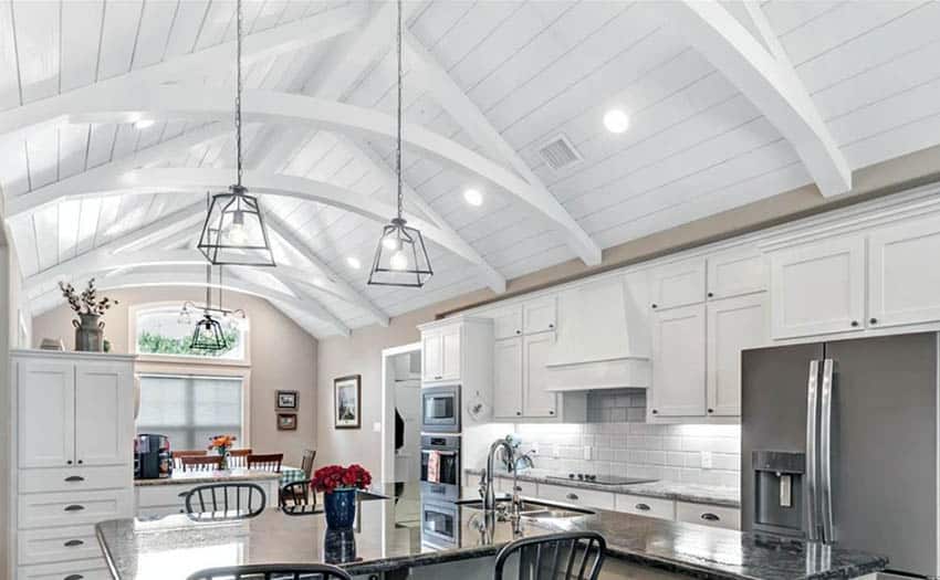 Kitchen with painted white ceiling, recessed lights and pendant lights over island