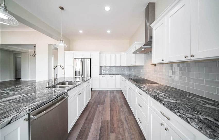 Large kitchen with white cabinets and black and white quartz countertops