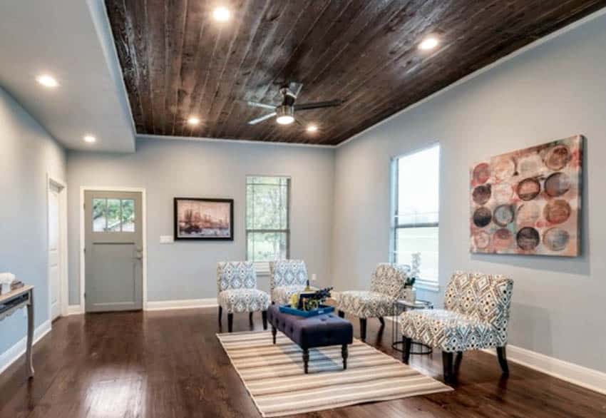 Room with DIY wood ceiling. grey walls, upholstered chairs and ceiling fan