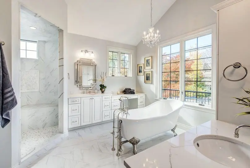 Bathroom with marble shower, mirror, bench, and claw foot tub