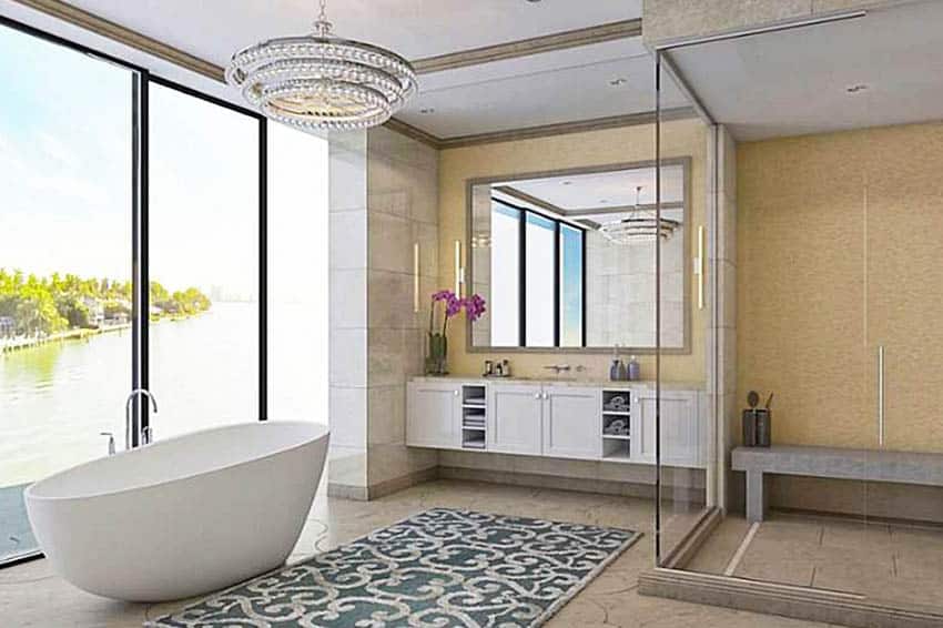 Luxury modern bathroom with glass shower and stone bench tub water views