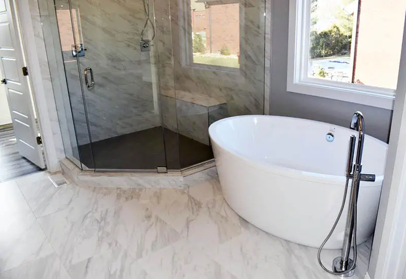Marble bathroom with window, shower, and bench