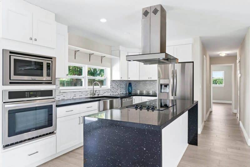 Modern Kitchen With White Cabinets Black Quartz Waterfall Countertop Island 800x534 