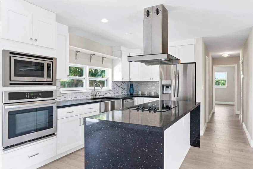 Modern new home kitchen featuring black speckled quartz waterfall countertop on island