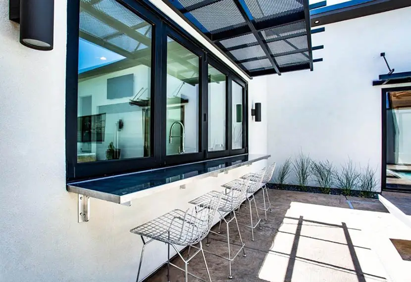 Outdoor patio with windows closed and wrought iron chairs