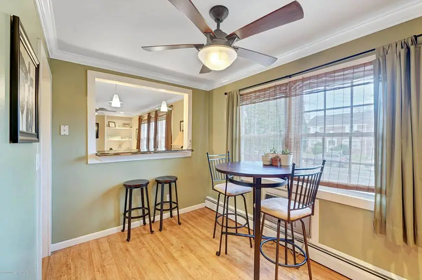Breakfast nook with round table and chairs with bar with stools and fan on the ceiling