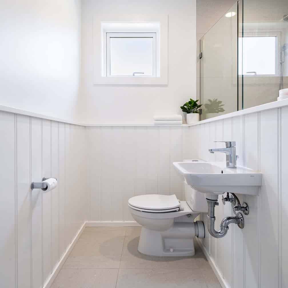 Wide vertical beaded planks giving a clean minimal look in a compact bathroom