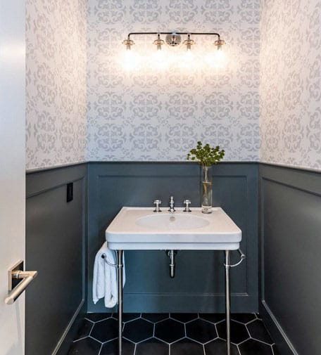 Small bathroom with black wainscoting and wallpaper