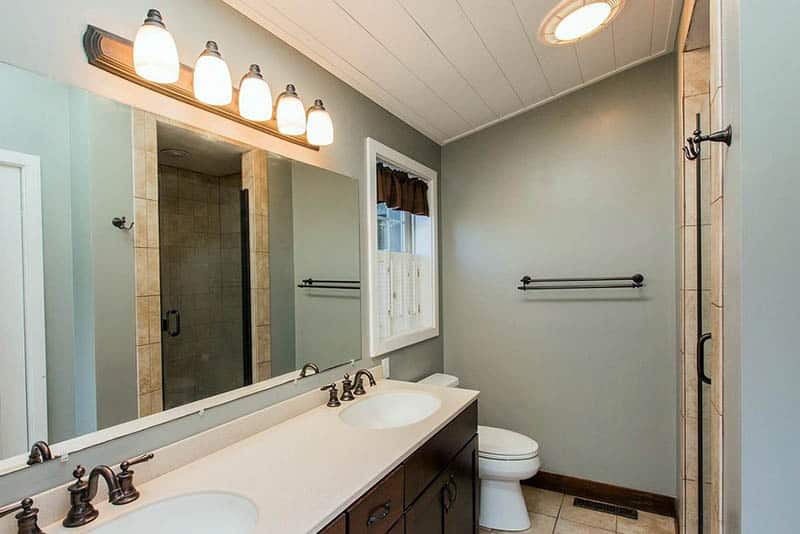Small bathroom sloped ceiling, double sink vanity counter with overhead lights