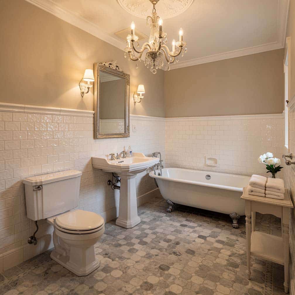 White textured ceramic tile half-wall treatment with grey and cream mosaic floor tile and chandelier