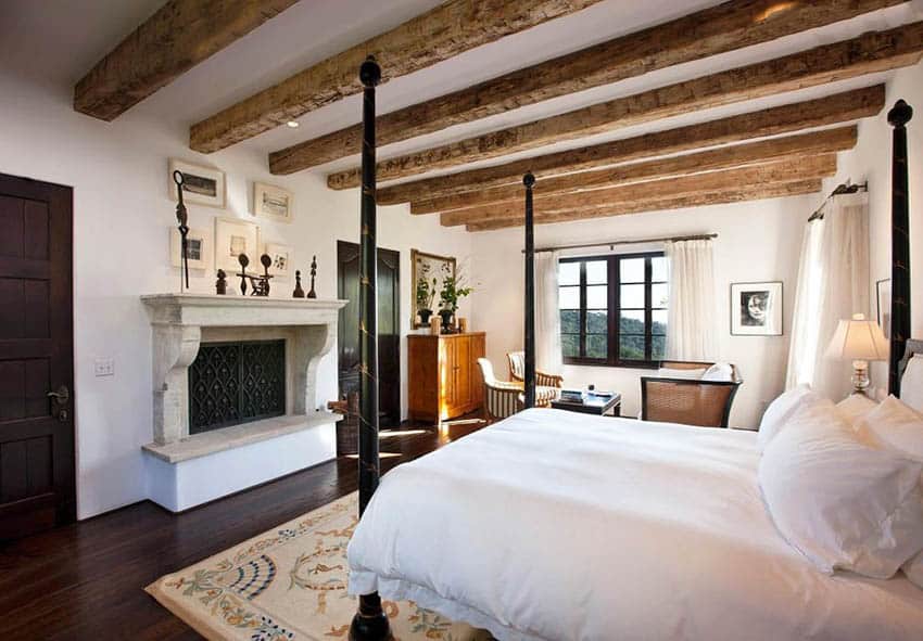 Traditional master bedroom with faux wood beam ceiling maple hardwood flooring and fireplace
