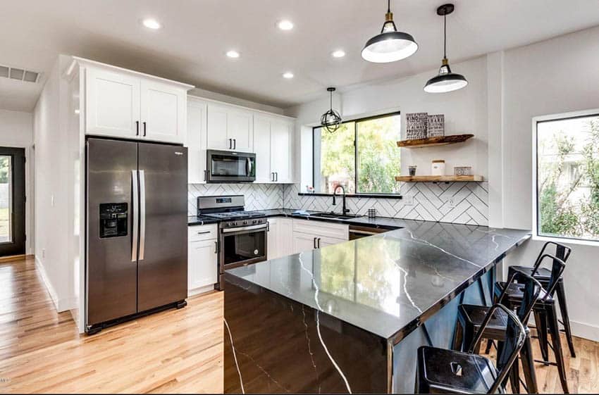 U shaped kitchen with white cabinets and black quartz countertop