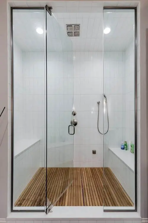 Walk in shower with two benches and teak floor