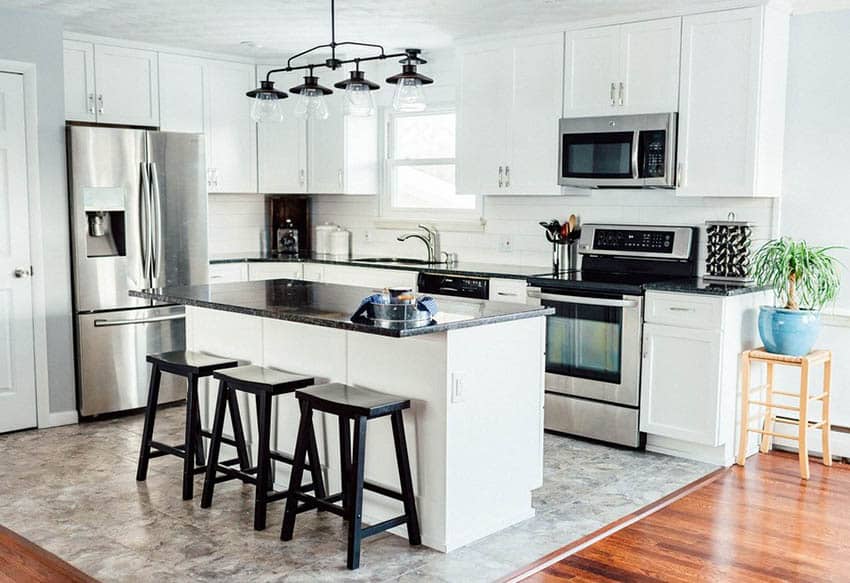 White kitchen cabinets with dark countertops and gray wall paint