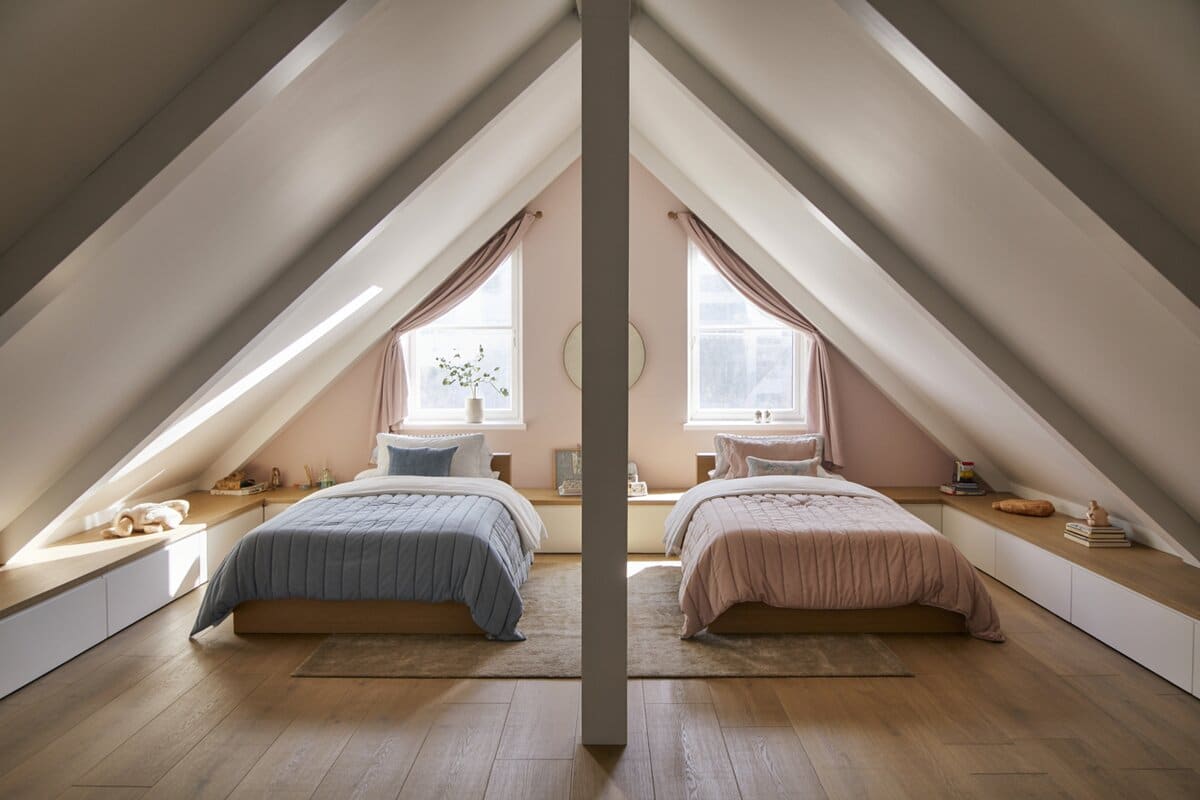 Twin attic beds tucked under sloped ceilings by two dormer windows