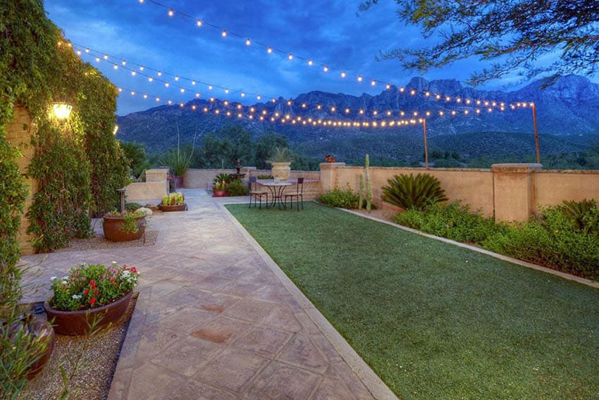 Backyard with hanging string lights and poles above outdoor dining