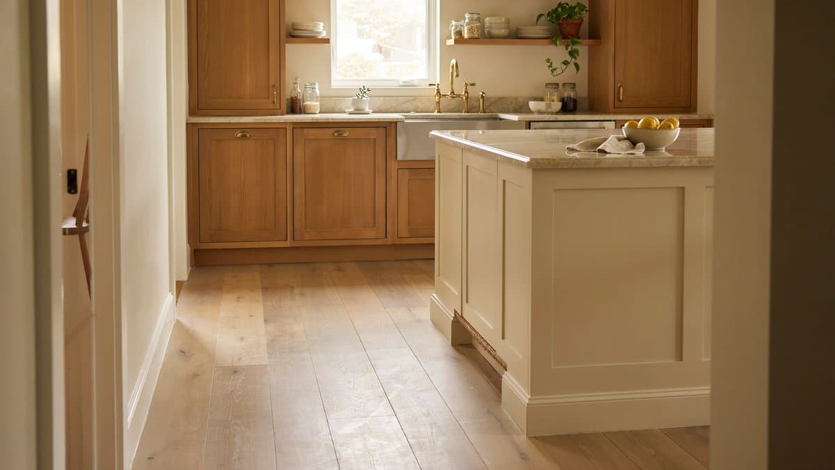Solid wood kitchen cabinets framing a cream island beneath beige marble countertops