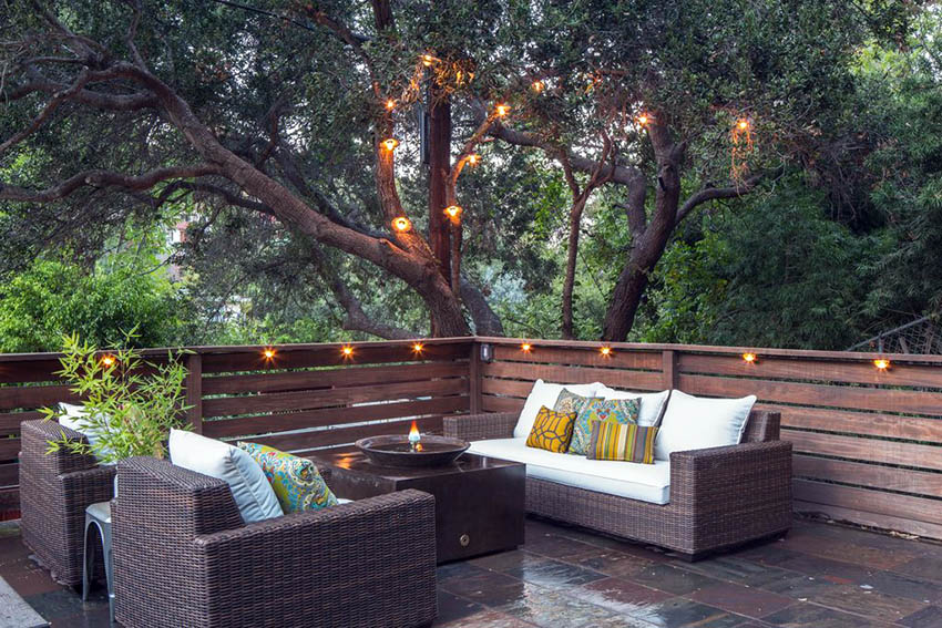Contemporary deck with string lights and tree