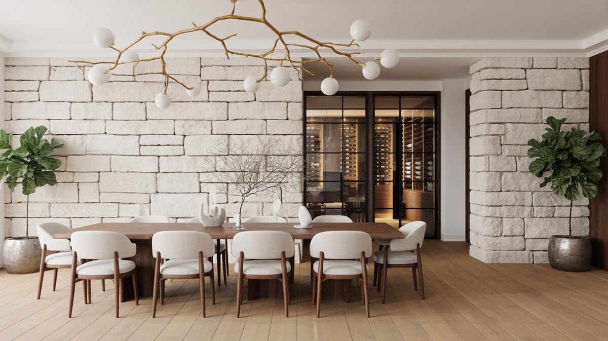 Dining room with cream limestone stacked stone walls, gold branch chandelier, and wine cellar