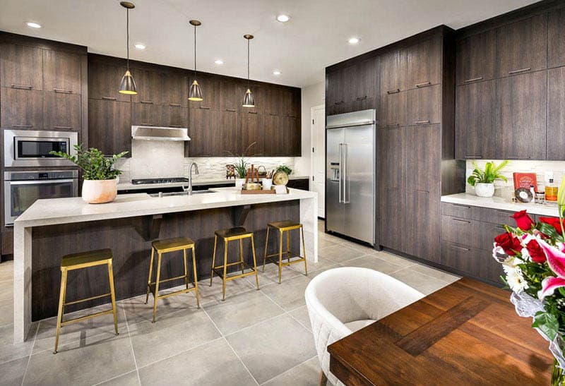 Kitchen with porcelain tile flooring, dark wood veneer cabinets and white quartz countertops