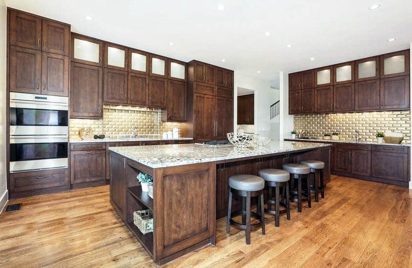 Kitchen with solid wood brown cabinets, brick tile backsplash and light wood flooring