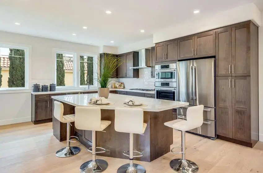 Kitchen with veneer cabinets, island, wood flooring and white stools