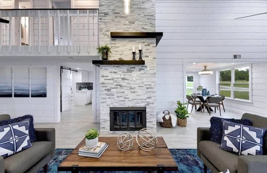 Dry stacked style stone with fireplace, shiplap walls, blue cushions and brown center table