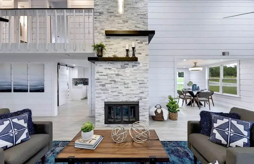 Dry stacked style stone with fireplace, shiplap walls, blue cushions and brown center table