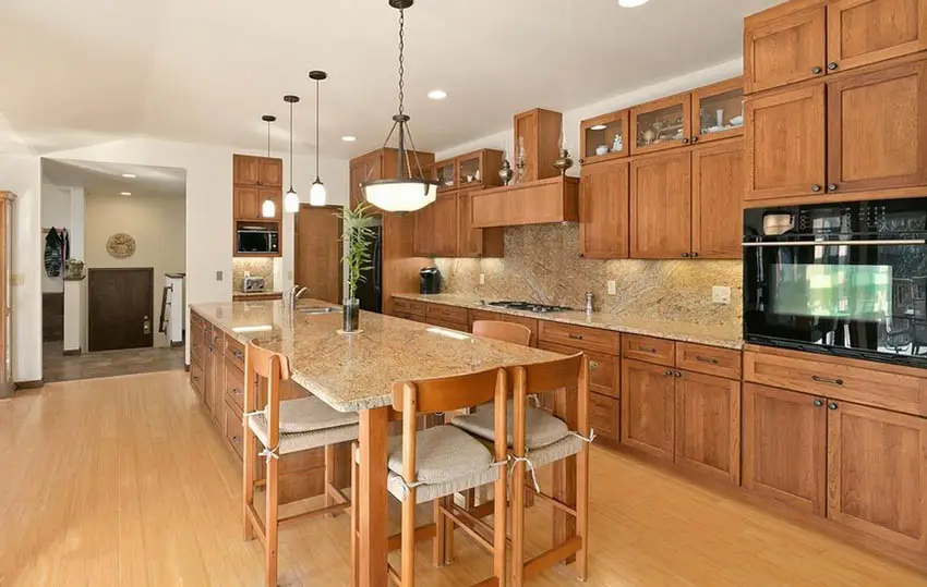 Kitchen with bamboo flooring, wood cabinets and beige granite countertops