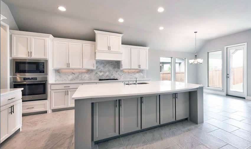 Kitchen with ceramic tile flooring, white cabinets, gray island and white quartz countertop