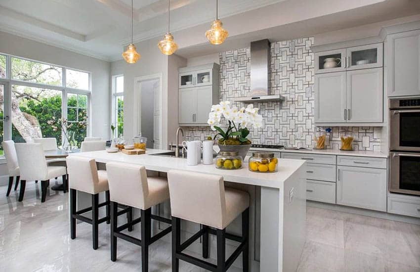Beautiful kitchen with ceramic tile floors, light grey cabinets, white quartz countertops and large dining island