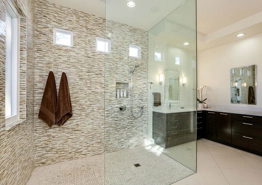 Large glass walk in shower with no door and mosaic tile