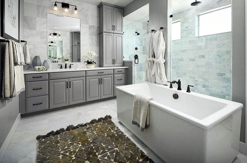 Master bathroom with marble walk in shower gray vanity and freestanding tub