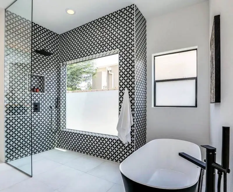 Shower with bold wall design and black tub