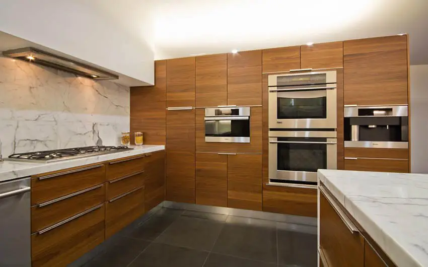 Kitchen with medium density finerboard cabinets, stone backsplash and dark floor tile